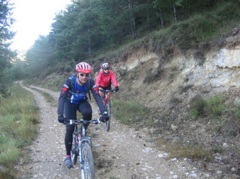 Sant Julià de Cerdanyola i al darrera el Pedraforca Sílvia i Toni baixant en bicicleta